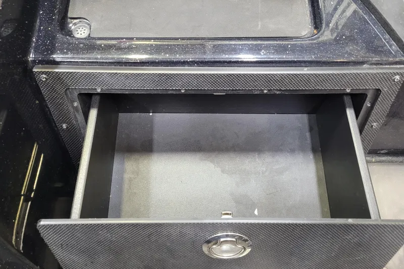 Slide: The Image of Open storage compartment in 2025 Triton 21XP boat, featuring a sleek black design. - 27