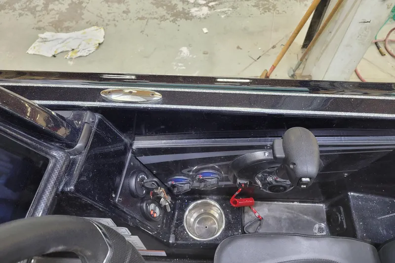 Slide: The Image of Control panel of a 2025 Triton 21XP boat with steering wheel and throttle lever. - 32