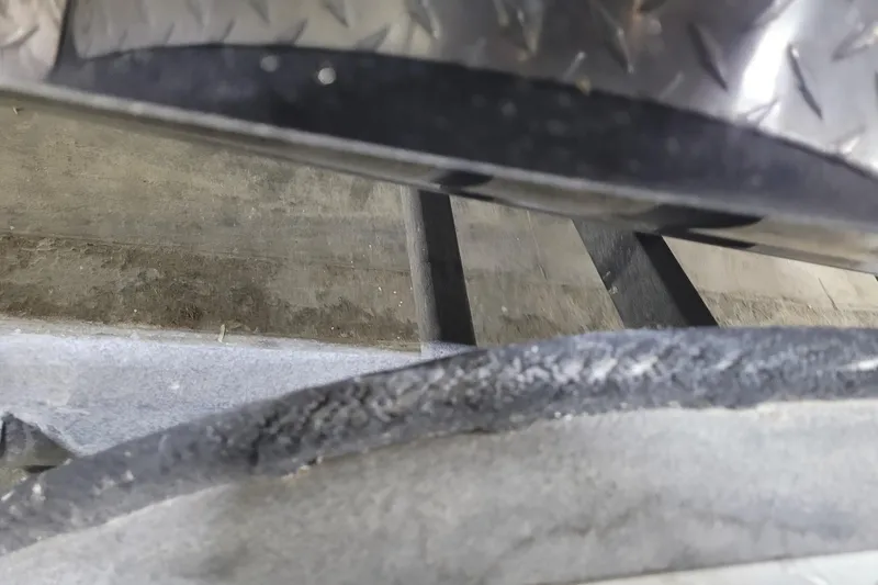 Slide: The Image of Close-up of a 2025 Triton 21XP boat trailer with textured metal and worn surface. - 33