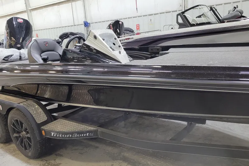 Slide: The Image of 2025 Triton 21XP boat in showroom, featuring sleek black design and modern interior. - 39