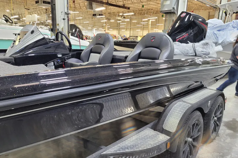 Slide: The Image of 2025 Triton 21XP boat with sleek black design and dual seats in a showroom. - 40