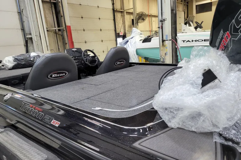 Slide: The Image of 2025 Triton 21XP boat interior in a garage, featuring seats and equipment. - 41