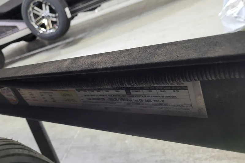 Slide: The Image of Close-up of a 2025 Triton 21XP vehicle label with tire and wheel in background. - 47