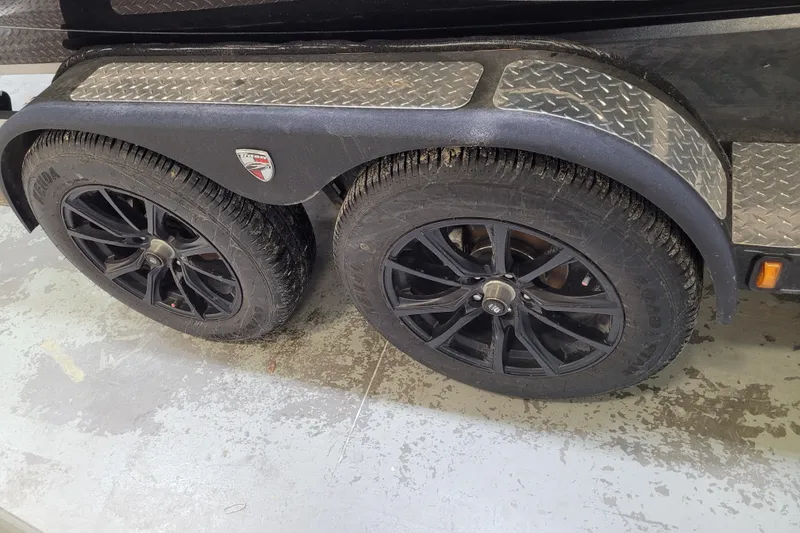 Slide: The Image of 2025 Triton 21XP trailer with dual black alloy wheels and diamond plate fender. - 49