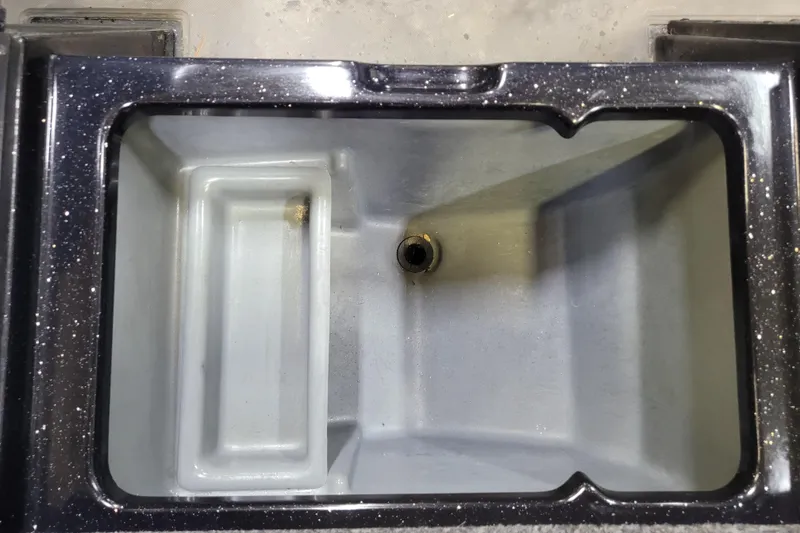 Slide: The Image of Interior view of 2025 Triton 21XP boat compartment with drain plug. - 6