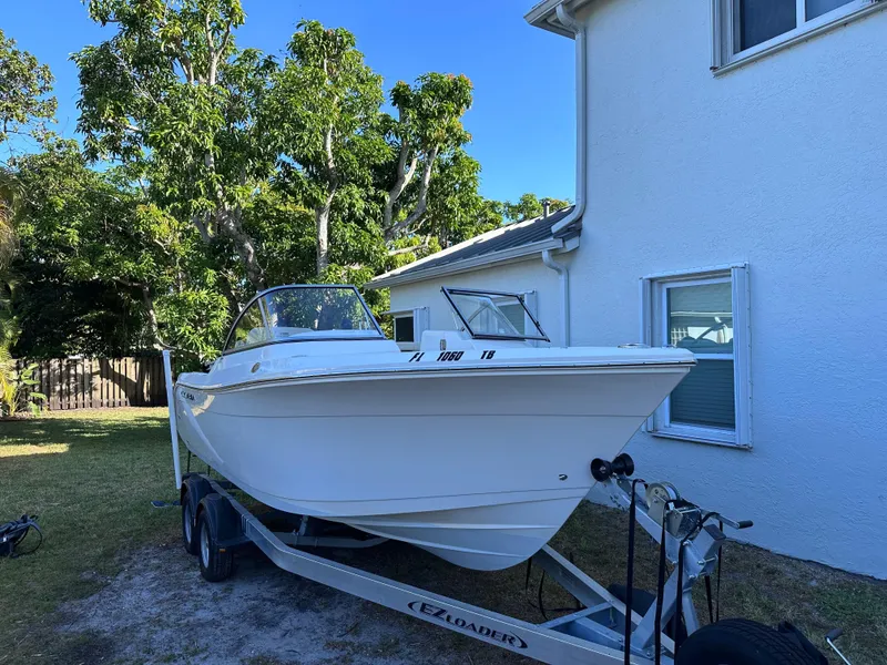 Slide: The Image of 2022 Cobia 220 Dual Console boat on trailer beside house. - 7