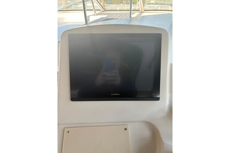 Slide: The Image of Garmin display on 2000 Cruisers 3870 yacht dashboard, reflecting surroundings. - 14
