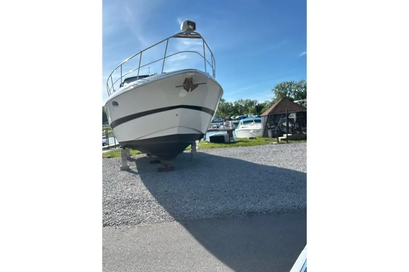 Slide: The Image of 2000 Cruisers 3870 boat docked, rear view with black canopy and "Selah" name visible. - 3
