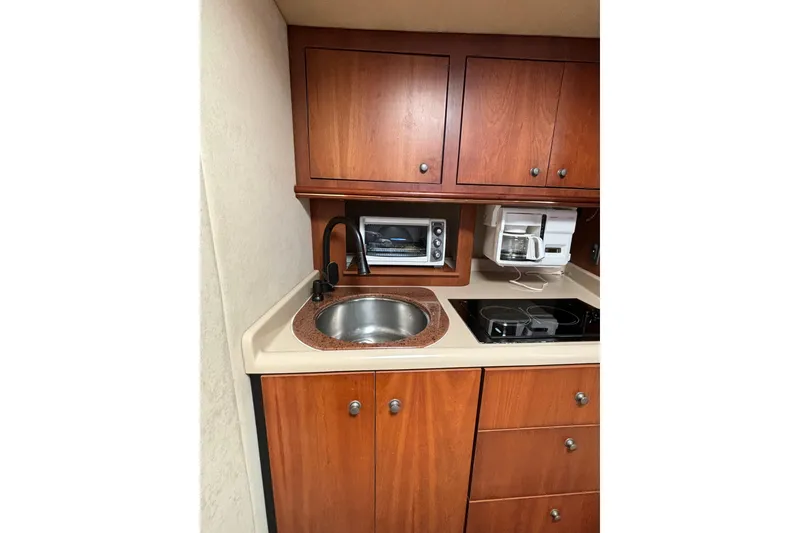 Slide: The Image of Compact kitchen in a 2000 Cruisers 3870 yacht with wooden cabinets and modern appliances. - 34