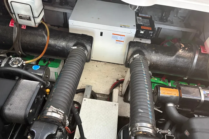 Slide: The Image of Engine compartment of a 2000 Cruisers 3870 boat, featuring hoses and mechanical components. - 56