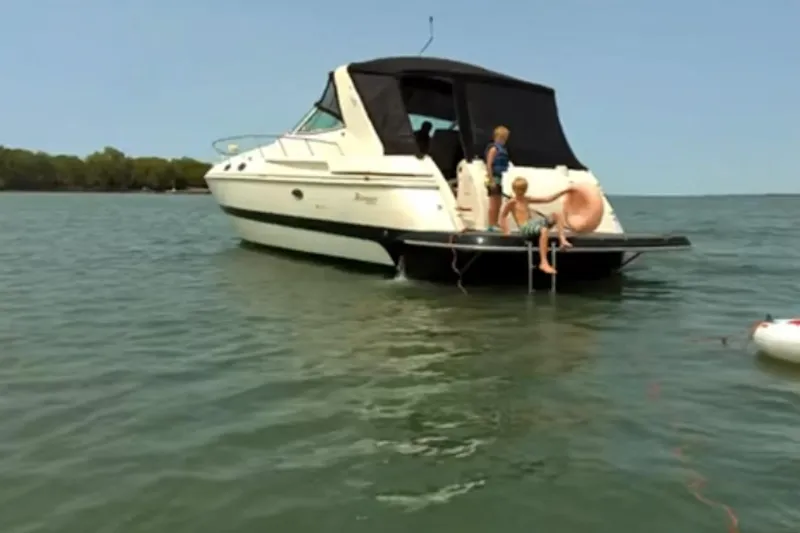 Slide: The Image of 2000 Cruisers 3870 yacht with children playing on the deck in open water. - 2