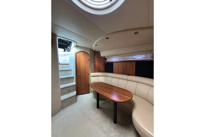 Slide: The Image of Interior of 2000 Cruisers 3870 yacht with curved seating and wooden table. - 29