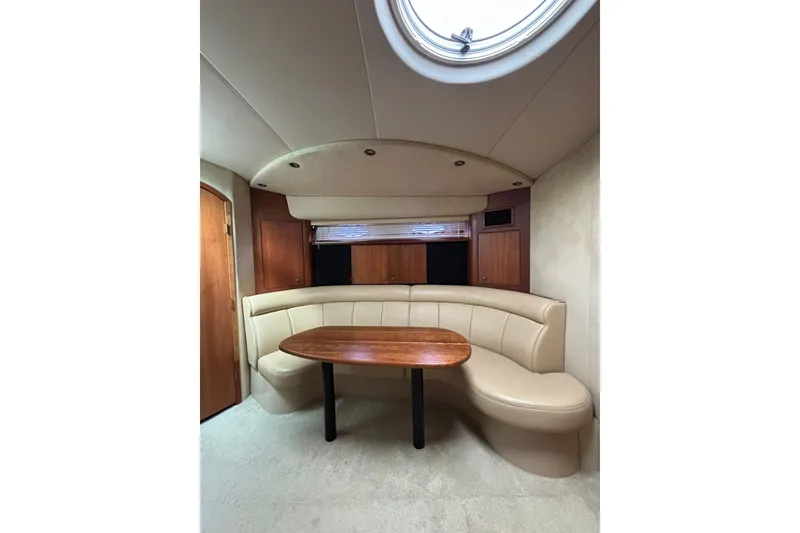 Slide: The Image of Interior of 2000 Cruisers 3870 yacht with curved seating and wooden table. - 30