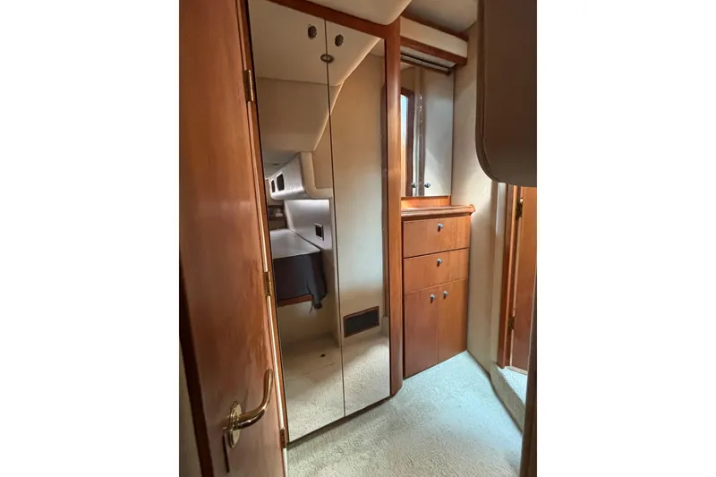 Slide: The Image of Interior of 2000 Cruisers 3870 yacht with mirrored closet and wooden cabinetry. - 32