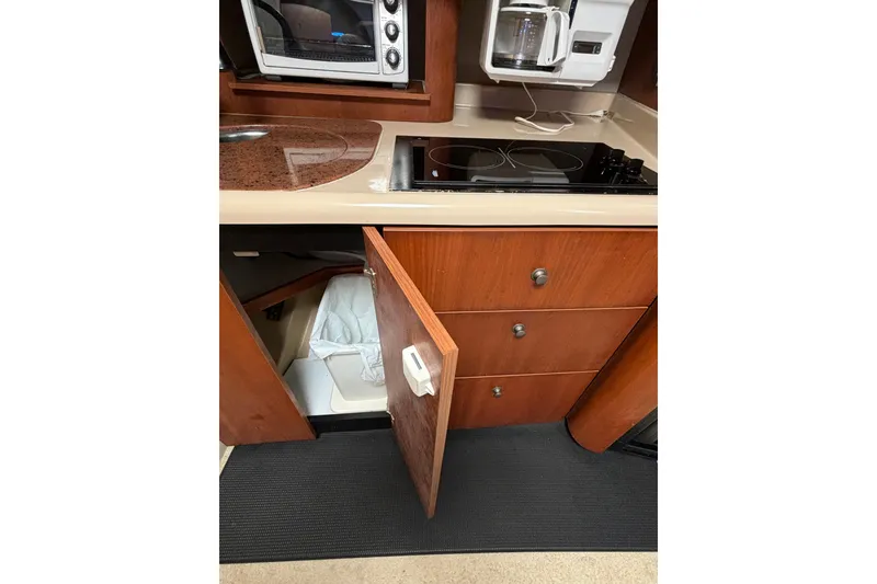 Slide: The Image of Kitchen area of a 2000 Cruisers 3870 yacht with stove, microwave, and open cabinet. - 33