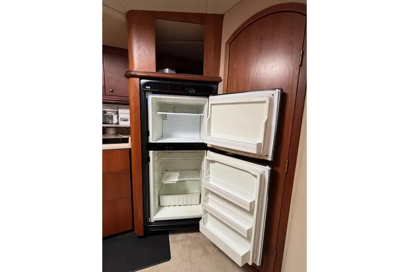 Slide: The Image of Open refrigerator in 2000 Cruisers 3870 yacht interior, showcasing storage space. - 39