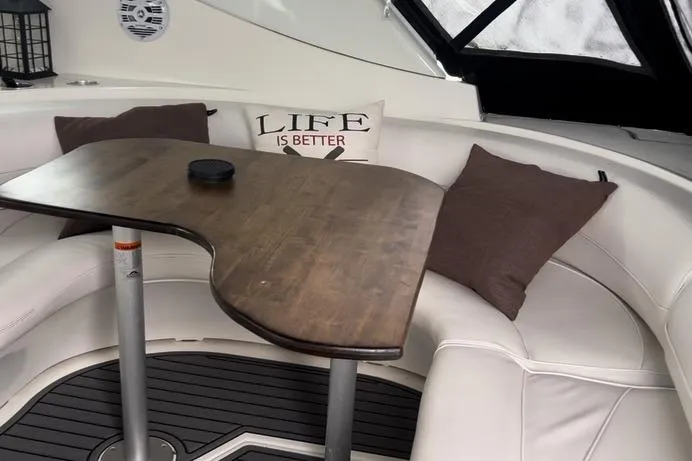 Slide: The Image of Cozy seating area on 2000 Cruisers 3870 yacht with wooden table and cushions. - 4