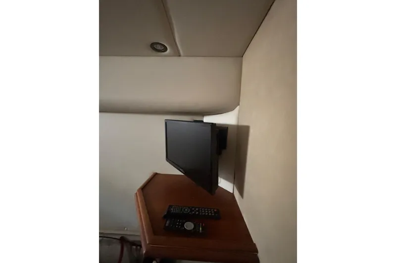 Slide: The Image of Wall-mounted TV and remote controls in a 2000 Cruisers 3870 yacht interior. - 44