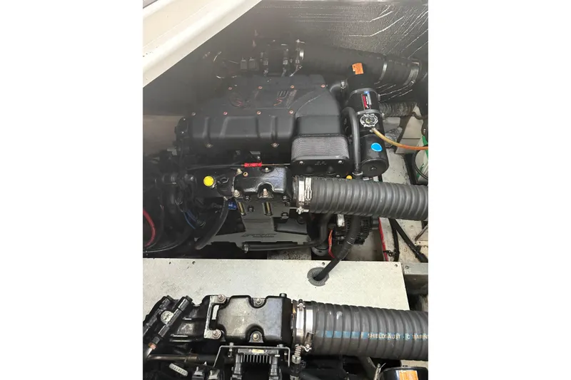 Slide: The Image of Engine compartment of a 2000 Cruisers 3870 boat, showcasing mechanical components and hoses. - 57