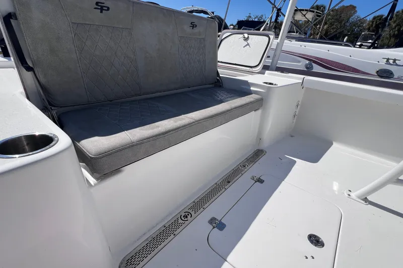 Slide: The Image of 2023 Sea Pro 248 Bay boat interior with cushioned seating and cup holder. - 18