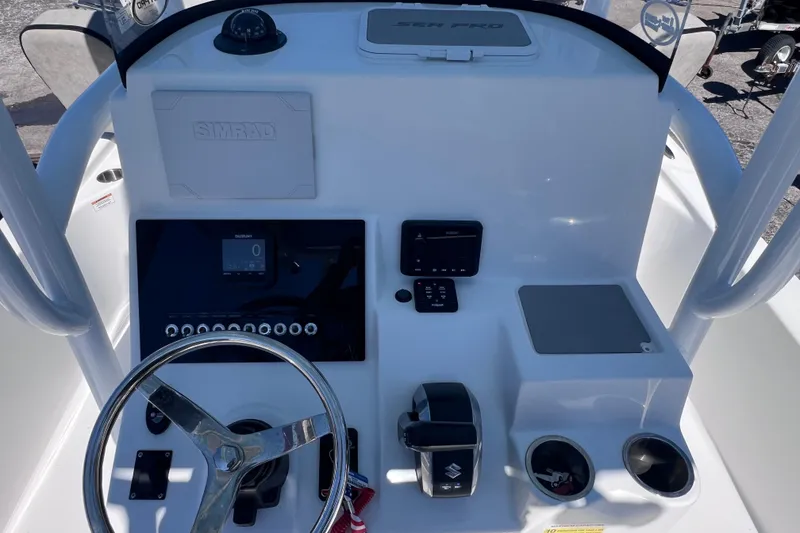 Slide: The Image of 2023 Sea Pro 248 Bay boat dashboard with steering wheel and control panel. - 24