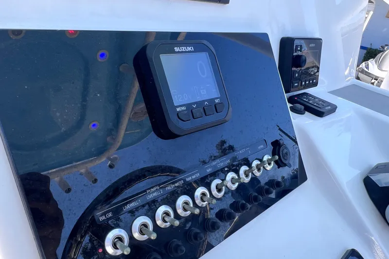 Slide: The Image of 2023 Sea Pro 248 Bay boat dashboard with Suzuki display and control switches. - 26