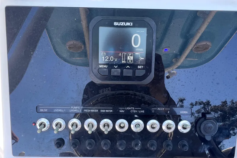 Slide: The Image of Control panel of 2023 Sea Pro 248 Bay boat with Suzuki display and switches. - 27