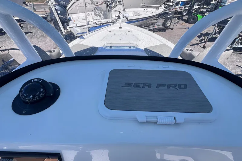 Slide: The Image of 2023 Sea Pro 248 Bay boat dashboard with compass and storage compartment. - 46