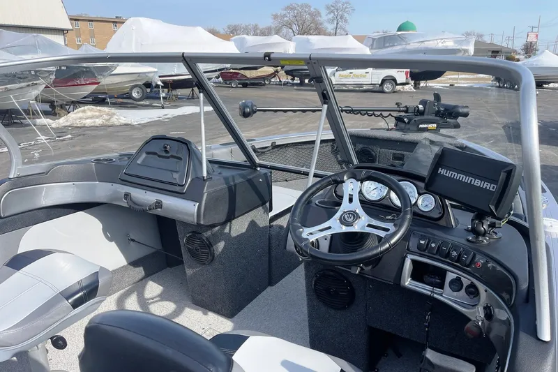 Slide: The Image of 2019 Crestliner 1850 Super Hawk boat interior with steering wheel and Humminbird electronics. - 2