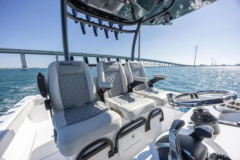Slide: The Image of 2025 Front Runner 36 Center Console boat interior with luxury seating and steering wheel, ocean backdrop. - 8