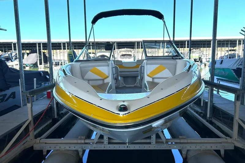 Slide: The Image of 2007 Glastron GT 205 boat with yellow accents docked in a marina. - 16