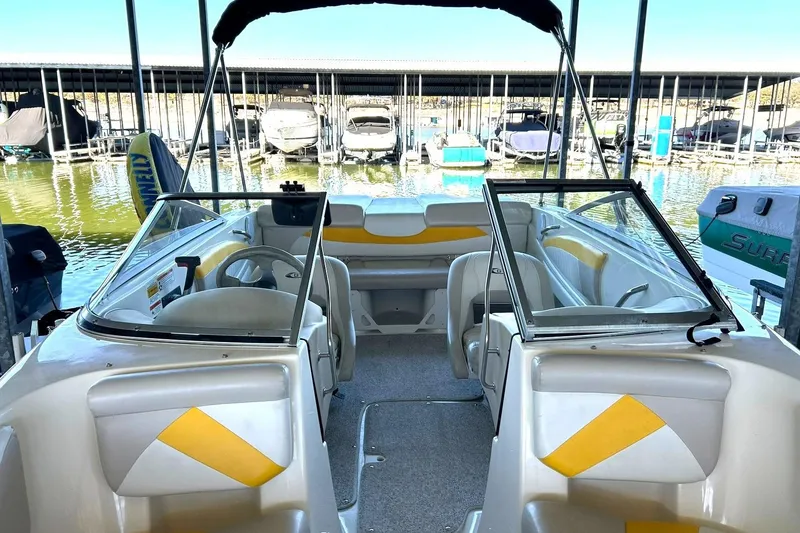 Slide: The Image of 2007 Glastron GT 205 boat interior with yellow accents, docked at a marina. - 35