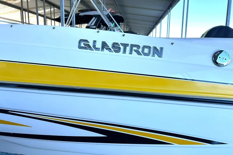 Slide: The Image of 2007 Glastron GT 205 boat with yellow and black detailing under a covered dock. - 39