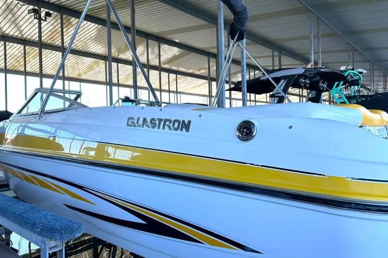 Slide: The Image of 2007 Glastron GT 205 boat with yellow accents in a covered marina. - 7