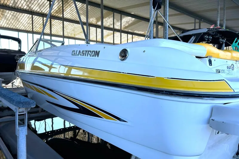 Slide: The Image of 2007 Glastron GT 205 boat with yellow accents in a covered dock. - 8