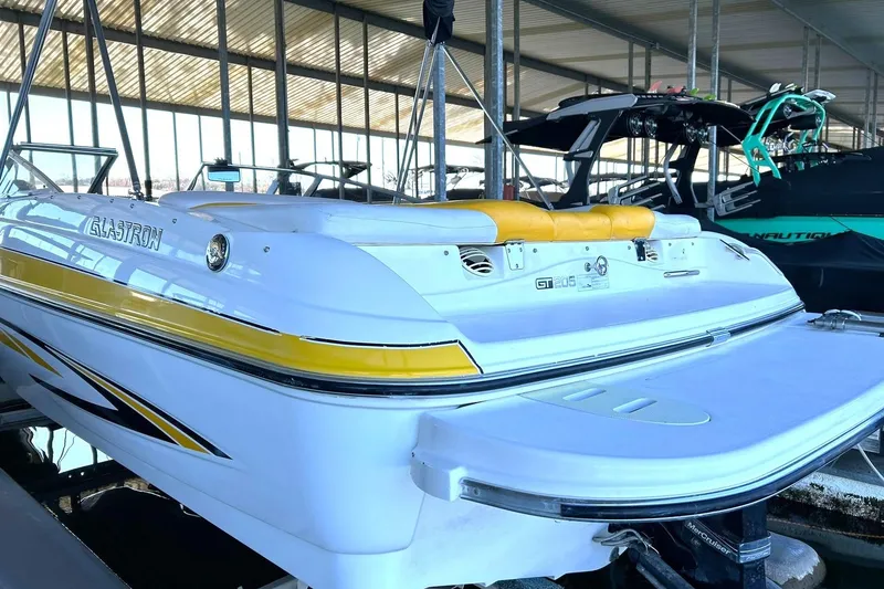 Slide: The Image of 2007 Glastron GT 205 boat with yellow accents docked in a marina. - 9