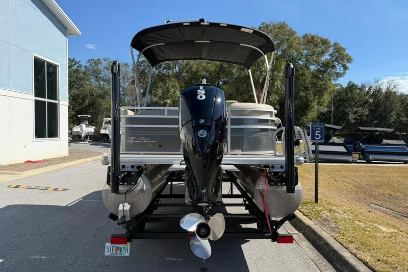Slide: The Image of 2024 Sun Tracker Party Barge 22 DLX pontoon boat with outboard motor, parked outdoors. - 2