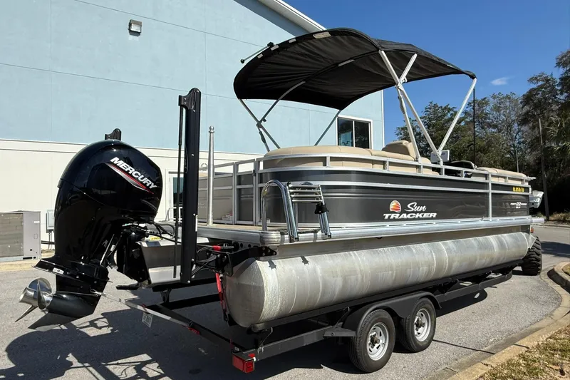 Slide: The Image of 2024 Sun Tracker Party Barge 22 DLX pontoon boat with Mercury outboard motor on trailer. - 3