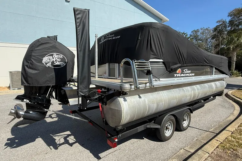 Slide: The Image of 2024 Sun Tracker Party Barge 22 DLX pontoon boat on trailer, covered and parked. - 8