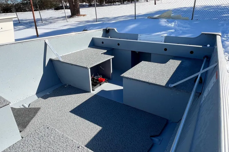 Slide: The Image of 2026 Lund SSV-16 boat interior with storage compartments, shown in a snowy outdoor setting. - 4
