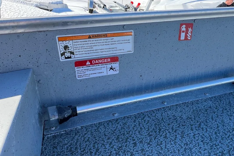 Slide: The Image of 2026 Lund SSV-16 boat interior with safety warning labels and textured flooring. - 9