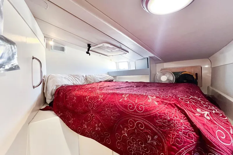 Slide: The Image of Cozy cabin interior of 2000 Leopard 38 yacht with red bedding and natural light. - 100