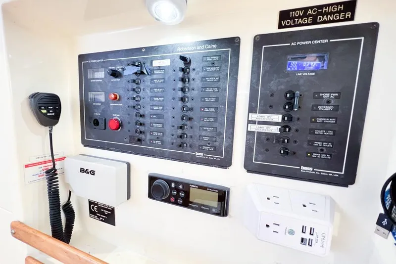 Slide: The Image of Electrical control panel on a 2000 Leopard 38 catamaran, featuring switches and voltage indicators. - 115