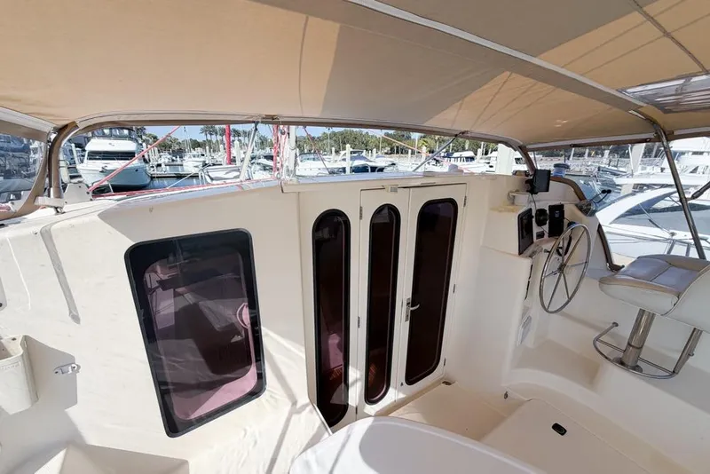 Slide: The Image of Leopard 38 catamaran cockpit with helm, seating, and marina view, 2000 model. - 119
