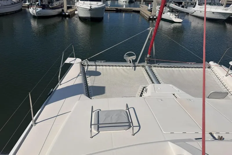 Slide: The Image of Leopard 38 catamaran from 2000 docked in a marina, showcasing deck and netting. - 147