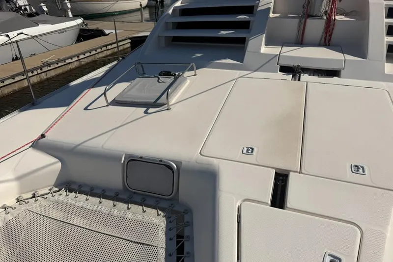 Slide: The Image of Leopard 38 catamaran deck, 2000 model, featuring hatches and netting at a marina. - 159