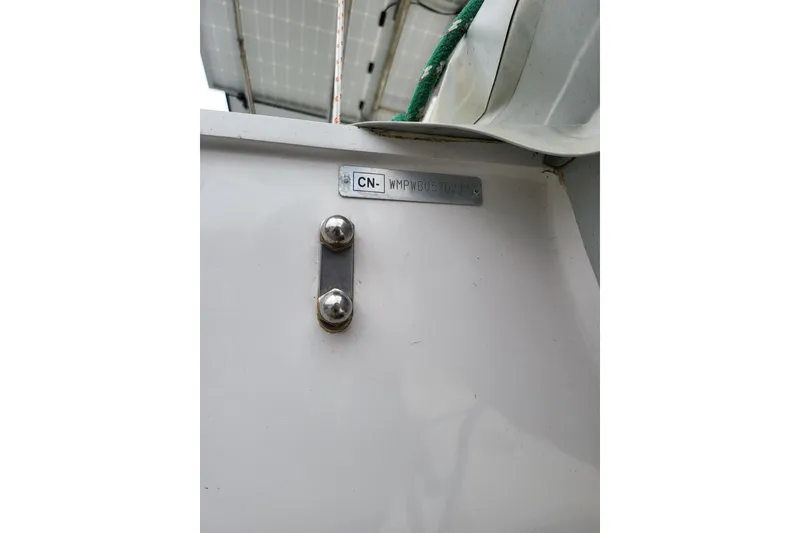 Slide: The Image of Catamaran Leopard 38, 2000 model, docked at marina with solar panels and red sail. - 16