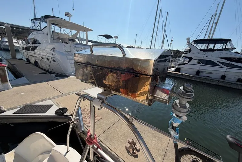 Slide: The Image of Docked Leopard 38 catamaran with a mounted grill, surrounded by luxury yachts. - 177