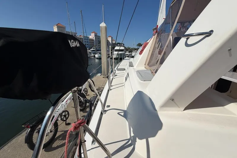 Slide: The Image of Leopard 38 catamaran docked at marina, showcasing deck and nearby bicycles. - 180