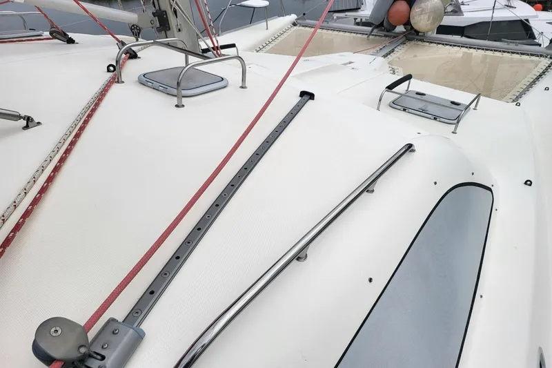 Slide: The Image of 2000 Leopard 38 catamaran docked at marina with red sail and white hull. - 19